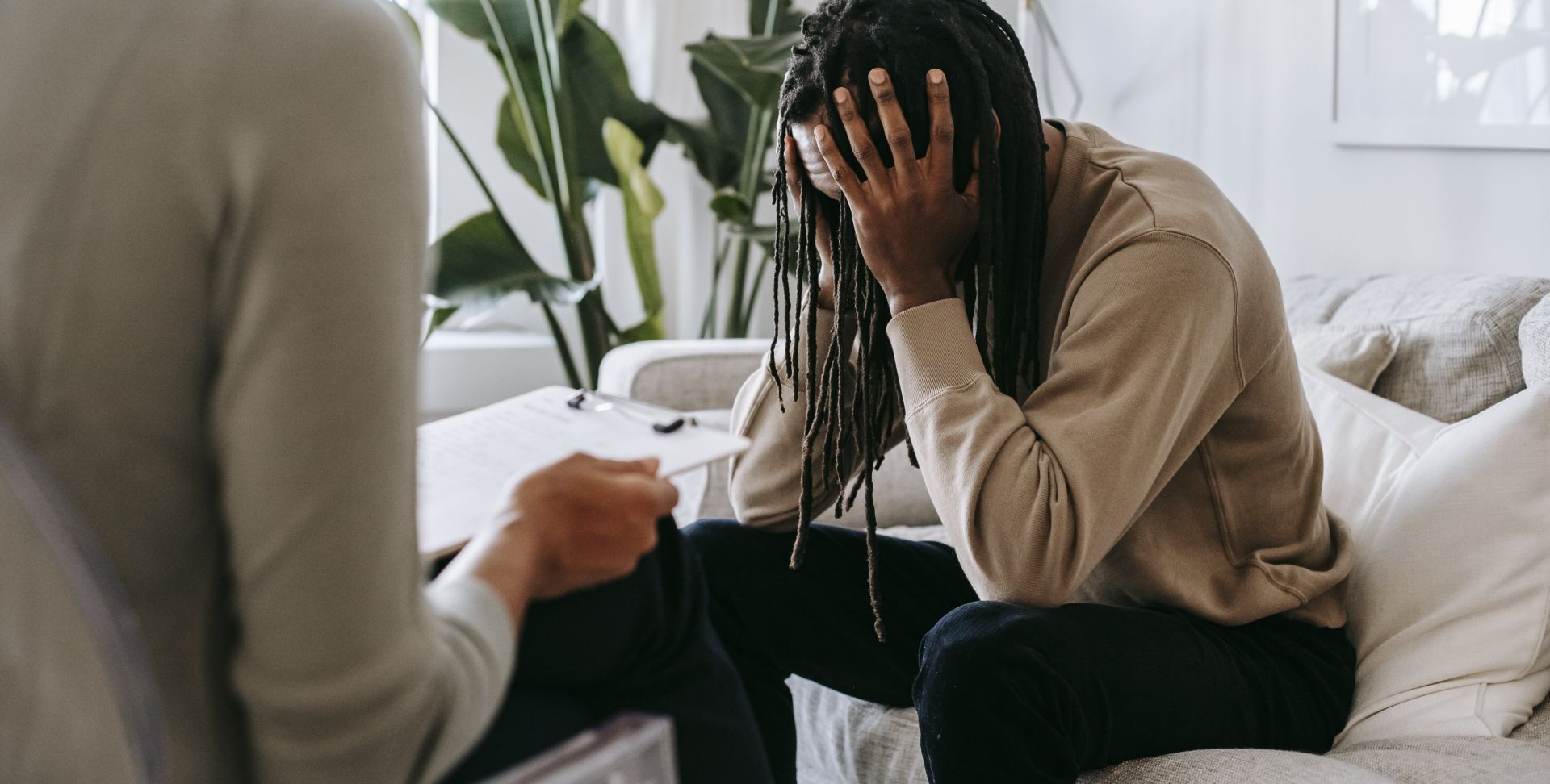 Stressed black man with dreadlocks in psychological office